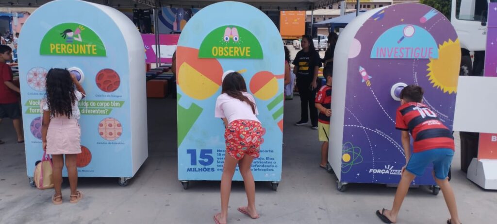 Uma garota de short e camisa rosa olhando para um objeto colorido